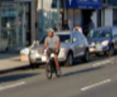 A blurry person in a tshirt & shorts on a bicycle. They are riding along the road striping that delineates the parking lane. Basically, about 2-3ft away from the parked cars; the deadly door zone. Because there's really nowhere safe to bike here.

Fuck this street.